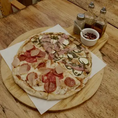 a pizza sitting on top of a wooden table at Casa Makoi in Tamanique