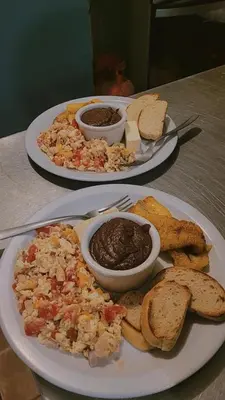 two plates of food sitting on a table with food at Casa Makoi in Tamanique