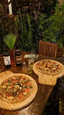 two pizzas sitting on top of a wooden table at Casa Makoi in Tamanique