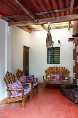 a living room with two chairs and a chandelier at Casa Makoi in Tamanique