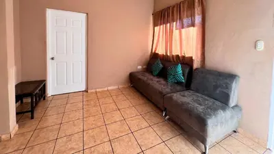 a living room with a couch and a door at Quinta Luna Mar, Residencial Las Veraneras in Acajutla