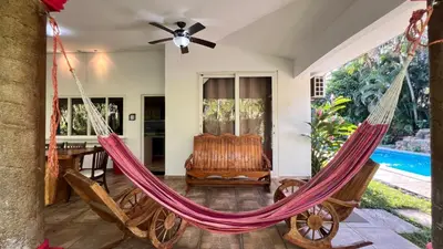 a hammock in the living room of a villa at Quinta Luna Mar, Residencial Las Veraneras in Acajutla
