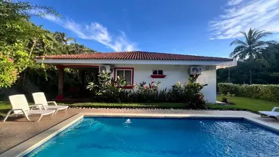 a villa with a swimming pool in front of a house at Quinta Luna Mar, Residencial Las Veraneras in Acajutla