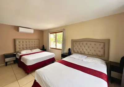 a bedroom with two beds and a window at Quinta del Carmen, Playa San Diego in La Libertad