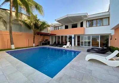 a swimming pool in front of a house at Quinta del Carmen, Playa San Diego in La Libertad