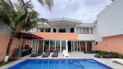 a villa with a swimming pool and a house at Quinta del Carmen, Playa San Diego in La Libertad