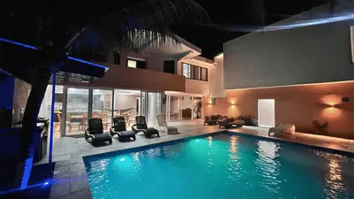 a swimming pool with chairs and a house at Quinta del Carmen, Playa San Diego in La Libertad