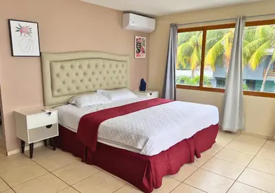 a bedroom with a large bed and a window at Quinta del Carmen, Playa San Diego in La Libertad