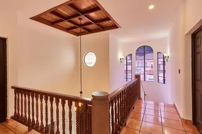 a staircase in a house with a wooden ceiling at New in the heart of the city 5 min to US Embassy in Nuevo Cuscatlán