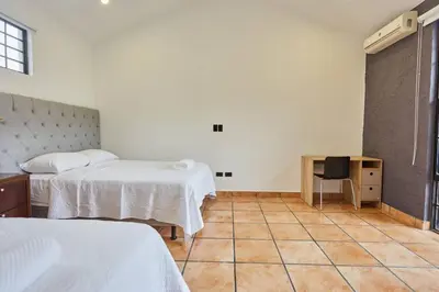 a bedroom with two beds and a tiled floor at New in the heart of the city 5 min to US Embassy in Nuevo Cuscatlán