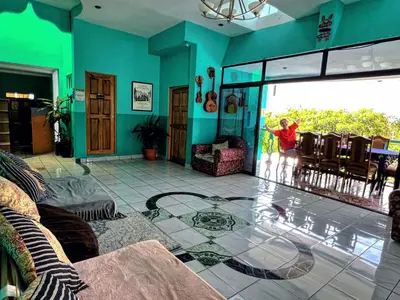 a living room with a child standing outside of a glass door at Samay Hostel in Juayúa