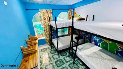 a room with two bunk beds and a blue wall at Samay Hostel in Juayúa