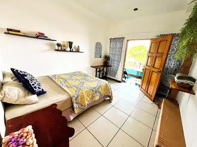 a bedroom with a bed and a door to a balcony at Samay Hostel in Juayúa