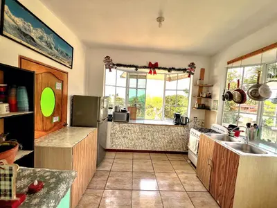 a kitchen with a large window and a counter top at Samay Hostel in Juayúa