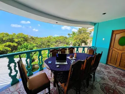 a balcony with a table with a laptop on it at Samay Hostel in Juayúa