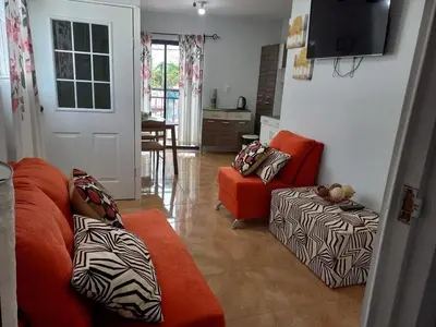 a living room with two orange couches and a television at Hostal Jasmin in Berlín
