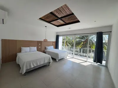 a bedroom with two beds and a large window at Hotel Paseo del Sol in La Paz