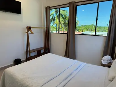 a bedroom with a bed and a large window at Hotel Paseo del Sol in La Paz