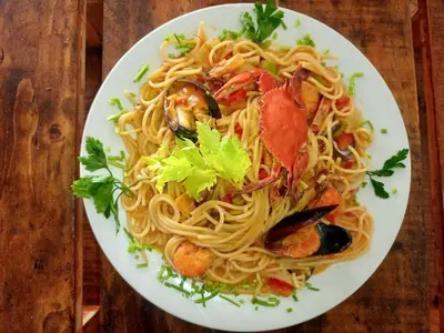 a plate of pasta with seafood on a table at Hotel Paseo del Sol in La Paz