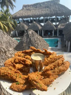 a plate of fried food with a dipping sauce at Hotel Paseo del Sol in La Paz
