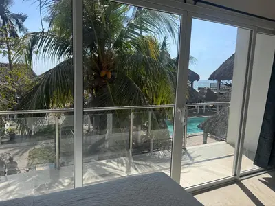 a bedroom with a view of the ocean from a window at Hotel Paseo del Sol in La Paz