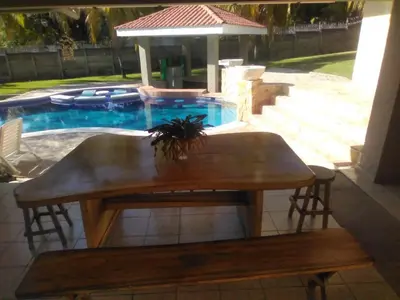 a wooden table and bench in front of a pool at Beach On The Rocks in El Zonte