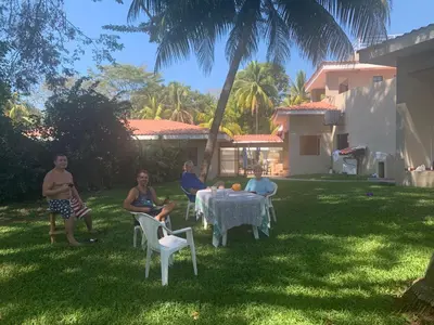 a group of people sitting around a table in a yard at Beach On The Rocks in El Zonte
