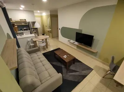 a living room with a couch and a tv at Acogedor Depto. en el corazón Santa Tecla in Nueva San Salvador