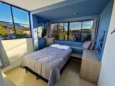 a bedroom with a bed and a large window at Acogedor Depto. en el corazón Santa Tecla in Nueva San Salvador