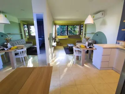 a kitchen and living room with tables and a couch at Acogedor Depto. en el corazón Santa Tecla in Nueva San Salvador
