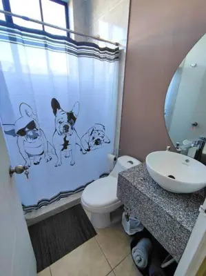 a bathroom with a shower curtain with dogs on it at Acogedor Depto. en el corazón Santa Tecla in Nueva San Salvador