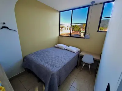 a small bedroom with a bed and two windows at Acogedor Depto. en el corazón Santa Tecla in Nueva San Salvador