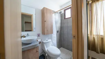 a bathroom with a toilet and a sink and a shower at Coco Surf Tropical Village in La Libertad