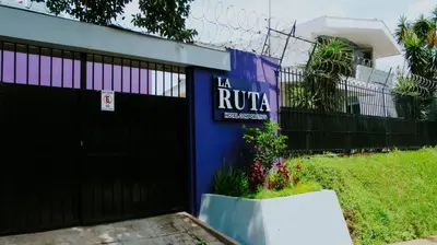 a building with a black gate and a sign on it at LA RUTA HOTEL CORPORATIVO in San Salvador