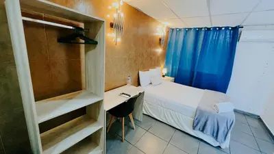 a small bedroom with a bed and a desk at LA RUTA HOTEL CORPORATIVO in San Salvador
