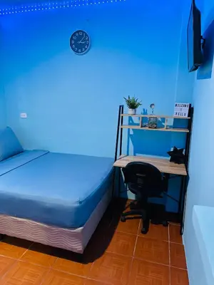 a blue room with a bed and a desk with a chair at Hospedaje Mónaco in San Miguel