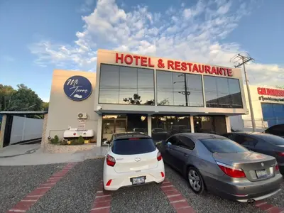two cars parked in front of a hotel and restaurant at Mi Tierra Aeropuerto SAL Hotel y Restaurante in San Luis