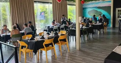 a group of people sitting at tables in a restaurant at Mi Tierra Aeropuerto SAL Hotel y Restaurante in San Luis