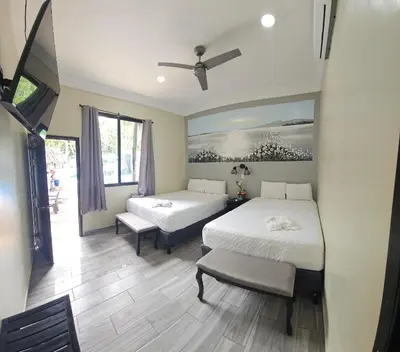 a bedroom with two beds and a bench in it at Mi Tierra Aeropuerto SAL Hotel y Restaurante in San Luis