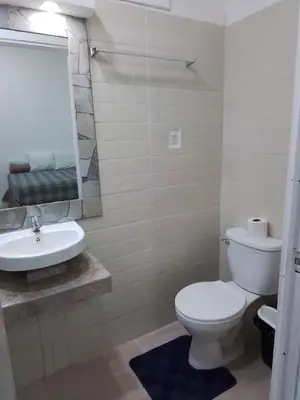a bathroom with a white toilet and a sink at Alojamientos Santa Marta La Unión in La Unión