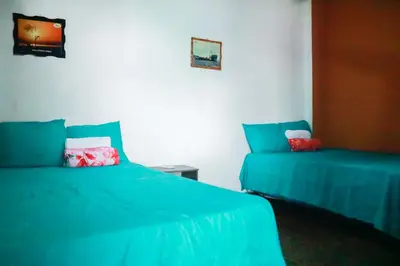 a bedroom with two beds with blue sheets and a table at Alojamientos Santa Marta La Unión in La Unión