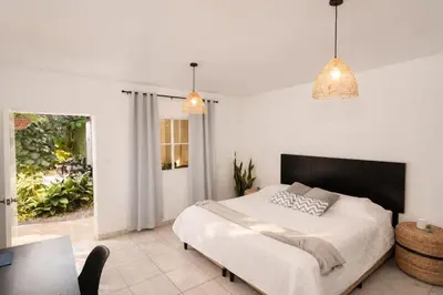 a bedroom with a large bed and a table at Habitación Deluxe Aire - Villa Valle Campo in Nahuizalco