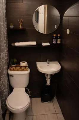a bathroom with a white toilet and a sink at Habitación Deluxe Aire - Villa Valle Campo in Nahuizalco