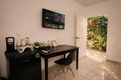a kitchen with a desk and a television on the wall at Habitación Deluxe Aire - Villa Valle Campo in Nahuizalco