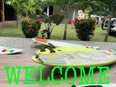 a yellow surfboard sitting on a table with the words welcome at HOTEL EL VIAJERO in La Libertad