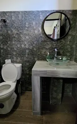 a bathroom with a sink and a toilet and a mirror at Altea Hostal in Santa Ana