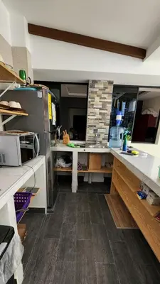a kitchen with white counter tops and a brick wall at Altea Hostal in Santa Ana