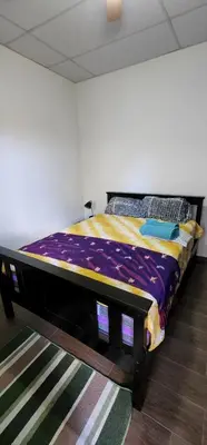 a bed in the corner of a room at Altea Hostal in Santa Ana