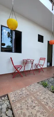 a patio with chairs and a table and a yellow lamp at Altea Hostal in Santa Ana