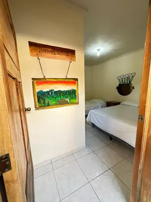 a room with two beds and a painting on the wall at Hostal y Restaurante Posada Real in La Palma